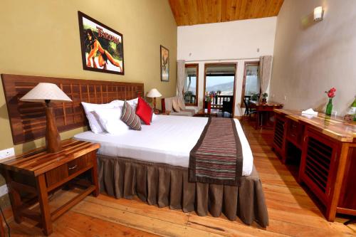 a bedroom with a bed and a desk with a bed sidx sidx sidx at Destiny - The Farm Resort in Ooty