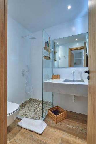 a bathroom with a sink and a toilet and a mirror at Casa Mardiva Sole in Kampos Paros