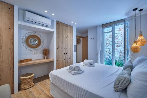 a bedroom with a white bed and a window at Casa Mardiva Sole in Kampos Paros