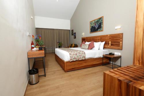 a hotel room with a bed and a table at Destiny - The Farm Resort in Ooty