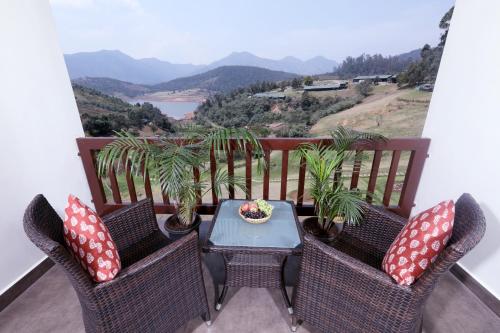 a balcony with a table and chairs with a view at Destiny - The Farm Resort in Ooty