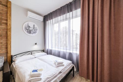 a small bedroom with a bed and a window at Затишні смарт-квартири в історичному центрі! in Uzhhorod