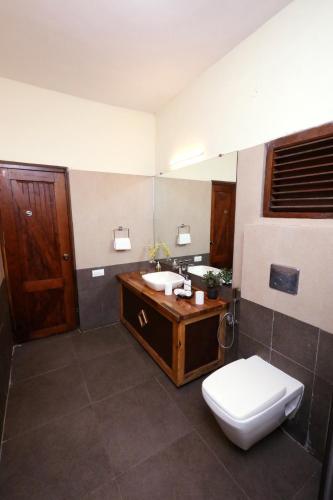 a bathroom with a sink and a toilet in it at Destiny - The Farm Resort in Ooty