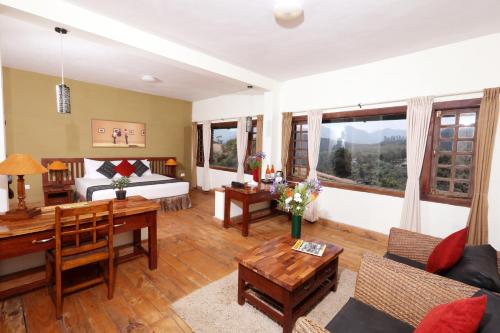 a living room with a bed and a table at Destiny - The Farm Resort in Ooty