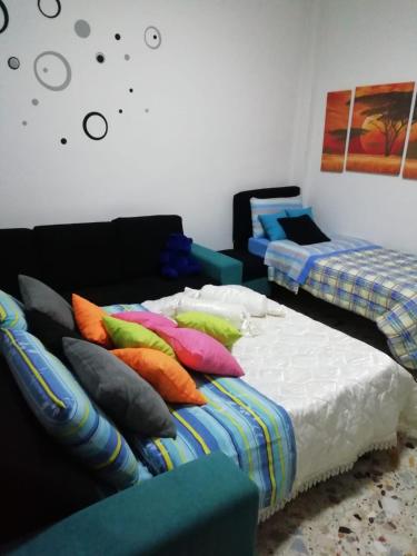 a room with two beds and a couch with pillows at Sole Sica in Pontecagnano