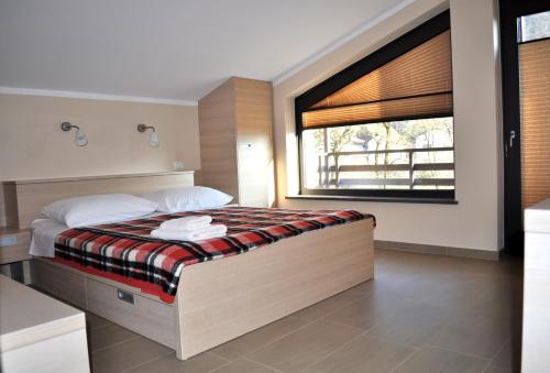 a bedroom with a large bed with a window at Hotel Penzion Kobala in Tolmin