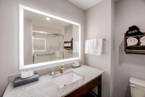 a bathroom with a sink and a large mirror at La Quinta by Wyndham Fort Worth Eastchase in Arlington