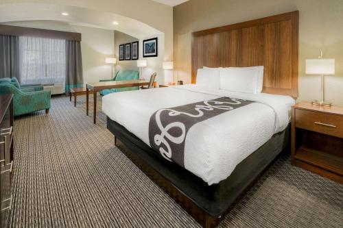 a hotel room with a large bed and a desk at La Quinta by Wyndham Fort Worth Eastchase in Arlington