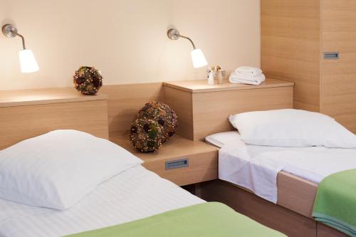 a bedroom with two beds and two lights on the wall at Hotel Penzion Kobala in Tolmin
