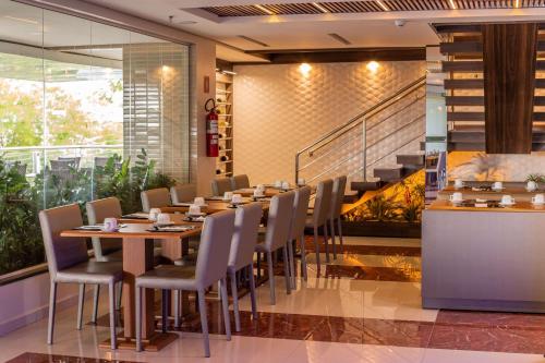 a dining room with a table and chairs and a staircase at Ramada by Wyndham Manaus Torres Center in Manaus