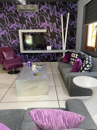 a living room with purple walls and a tv at Purple Villa in Paralimni