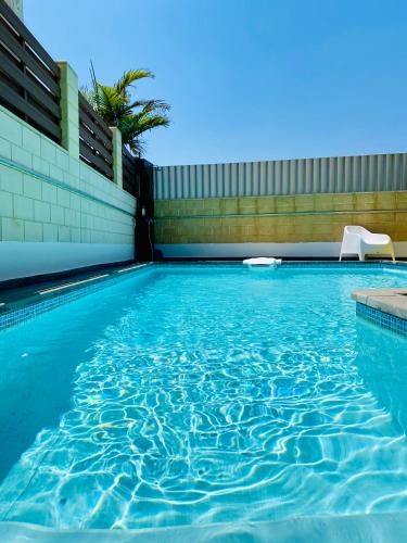 a swimming pool with a chair in the water at Purple Villa Protaras - Paralimni in Paralimni