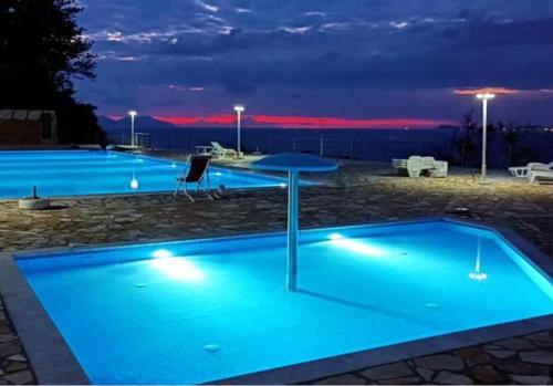 a group of three swimming pools at night at Sunset House in Vlorë