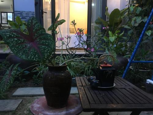 a black vase sitting on a table in a garden at Cherry Garden Homestay in Hoi An
