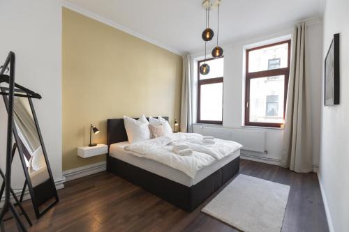 Schlafzimmer mit einem Bett mit weißer Bettwäsche und einem Fenster in der Unterkunft Bheaven I Jugendstil Premium Apartment in Bremerhaven