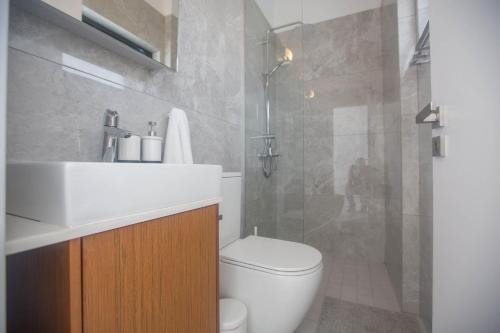 y baño con aseo, lavabo y ducha. en Anassa Seaview Villa - Stunning Panoramic Views en Protaras