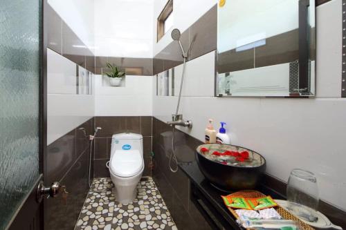 een badkamer met een toilet en een wastafel bij Cherry Garden Homestay in Hội An