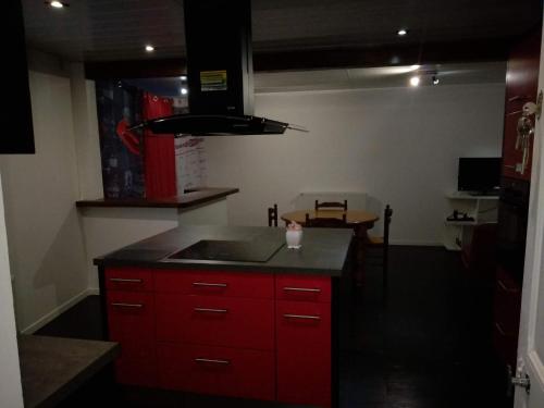 ヴィッテルにあるVittel location meubléのキッチン(赤いキャビネット、シンク付)