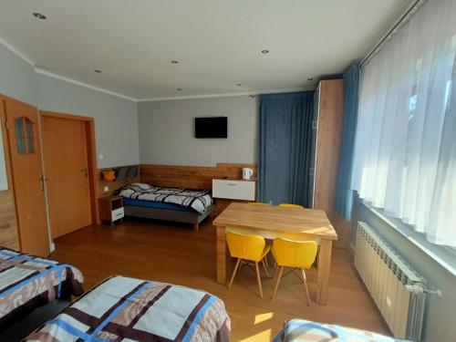 ジェロナ・グラにあるNoclegi Zielona Góra u Moniのテーブルとベッド2台が備わる部屋、ベッドルーム1室が備わるアパートメントです。