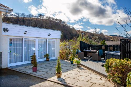 a patio with a table and chairs and a building at Katie's Flat in Oban
