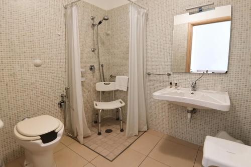 a bathroom with a toilet and a sink and a shower at Hotel Poetto in Cagliari