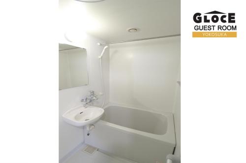 ein weißes Badezimmer mit Waschbecken und Spiegel in der Unterkunft GLOCE 横須賀 ゲストルーム 横須賀海軍基地 l Yokosuka Guest Room at NAVY BASE in Yokosuka