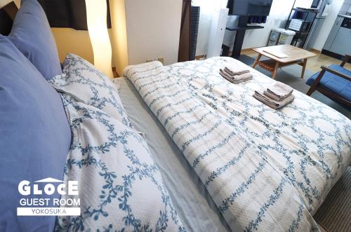 Cama con manta y almohadas azules y blancas en GLOCE 横須賀 ゲストルーム 横須賀海軍基地 l Yokosuka Guest Room at NAVY BASE, en Yokosuka