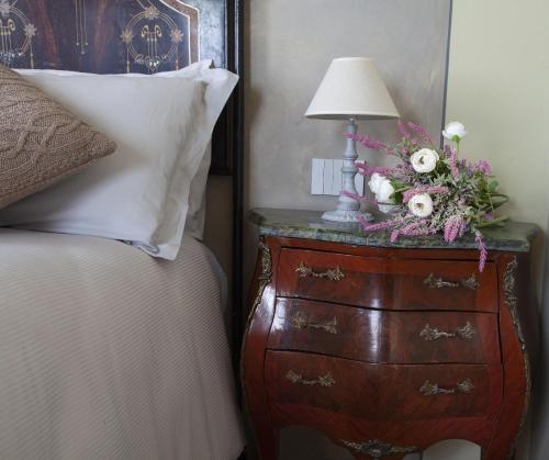 uma cómoda com um candeeiro ao lado de uma cama em B&B SASSO DI ROCCA em Gaggio Montano