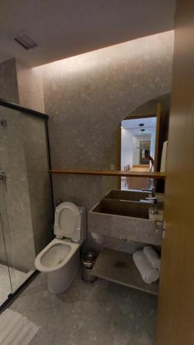 a bathroom with a toilet and a sink and a mirror at Salinas Premium Resort in Salinópolis