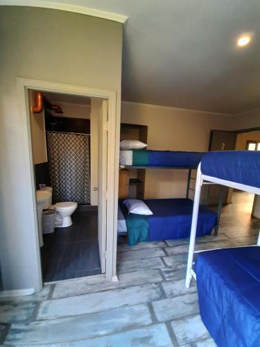 a room with two bunk beds and a bathroom at Aji Hostel in Santiago