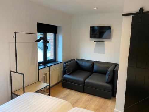 a living room with a couch and a tv at Rouleur Houffalize in Houffalize