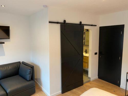 a living room with a black sliding barn door at Rouleur Houffalize in Houffalize
