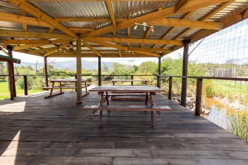 una terrazza in legno con tavoli da picnic di Tenikwa Wildlife Centre a Plettenberg Bay