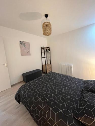 a bedroom with a bed and a chandelier at Le beauvais in Évron