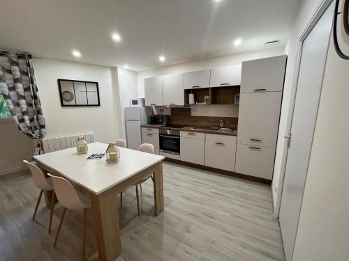 a kitchen with a table and chairs in a room at Le beauvais in Évron
