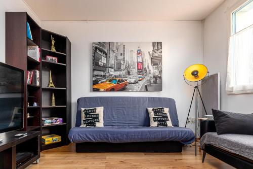 a living room with a blue couch and a yellow lamp at Paris Roissy CDG : Top Duplex - 3 bedrooms in Roissy-en-France