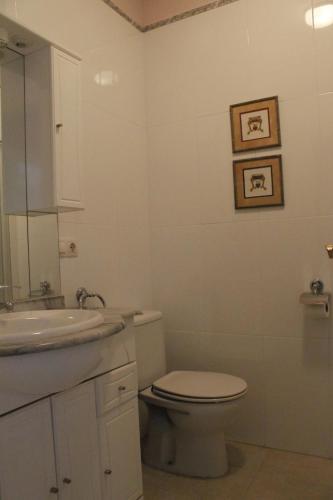 Baño blanco con aseo y lavamanos en La Casa del Patio Chico, en Aldeadávila de la Ribera