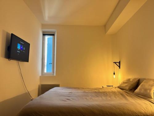 a bedroom with a bed and a flat screen tv at Lumineux T3 avec vue Mer dans le Centre Historique in Sainte-Maxime