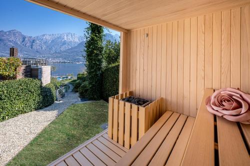 a wooden bench with a pink rose on it at Bellagio Village - Holiday Apartments by the Lake - Seasonal Warm Pool and Sauna in Oliveto Lario