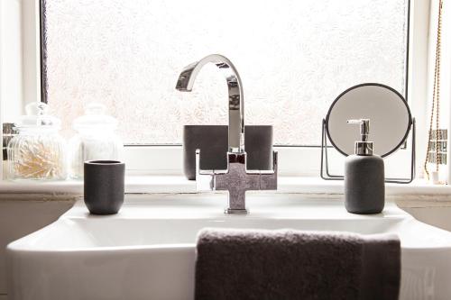 un lavandino del bagno con un rubinetto e uno specchio di Contractor house, sleeps 5, close to restaurant's and bars, Long stays available, Oveyo Accommodation a Middlesbrough