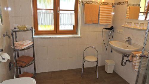 a white bathroom with a sink and a toilet at Gästehaus Weissenbauer in Lenggries