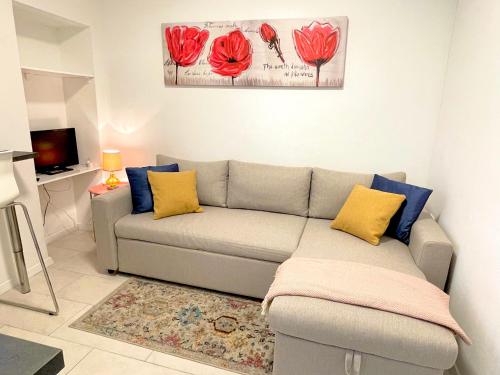 Happy Casa Isola Piccola في إيزولا: غرفة معيشة مع أريكة وأزهار حمراء