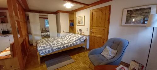 a small bedroom with a bed and a chair at Ferienhaus "Am Schleifenbach" in Saalfeld