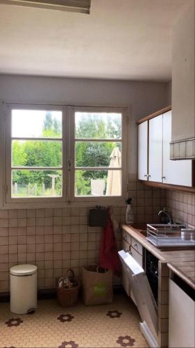 Il comprend une cuisine dotée de 2 fenêtres et d'un mur carrelé. dans l'établissement Villa Maléal, Grande maison de vacance à Soulac sur Mer, à Soulac-sur-Mer