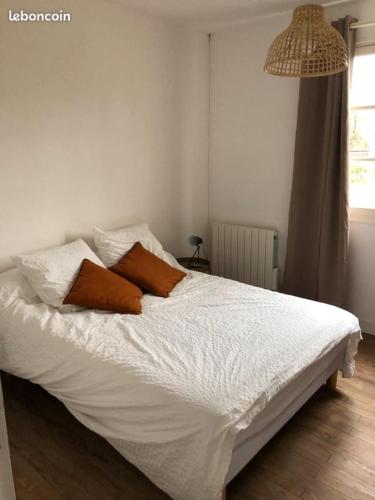 un lit avec deux oreillers dessus dans une chambre dans l'établissement Villa Maléal, Grande maison de vacance à Soulac sur Mer, à Soulac-sur-Mer