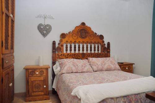 a bedroom with a bed with a wooden headboard at Apartamento Hiedra in Santillana del Mar