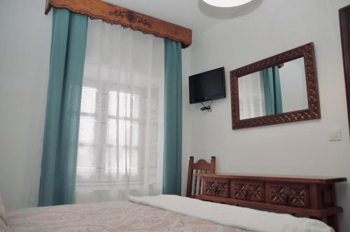 a bedroom with a bed with a mirror and a television at Apartamento Hiedra in Santillana del Mar