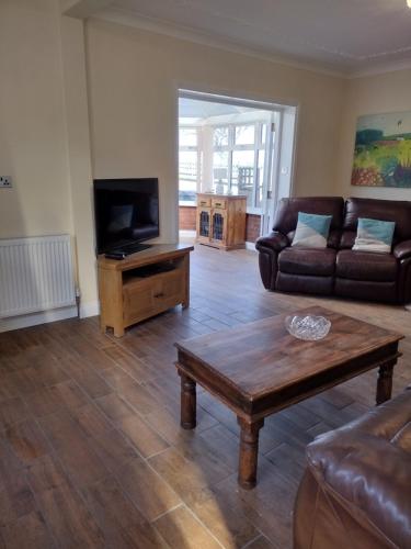 a living room with a couch and a television at The Denes in Mablethorpe