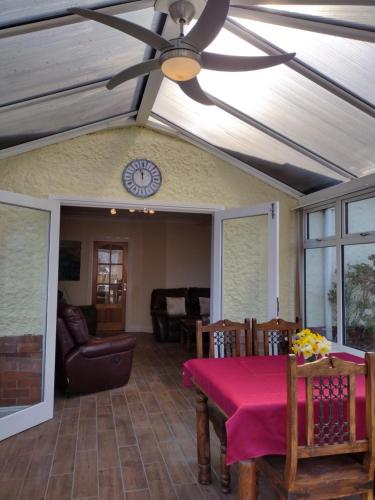 uma sala de jantar com uma ventoinha de tecto e uma mesa em The Denes em Mablethorpe