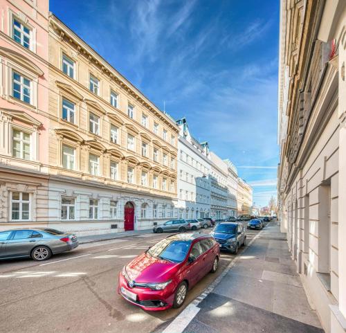 un coche rojo estacionado en una calle de la ciudad con edificios en Luxurious and Bright, 5 min to city center, en Viena